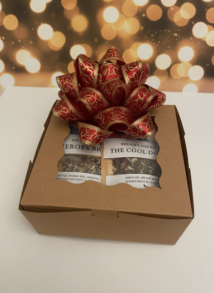 Gift box with a decorative bow and tea packages on a blurred background
